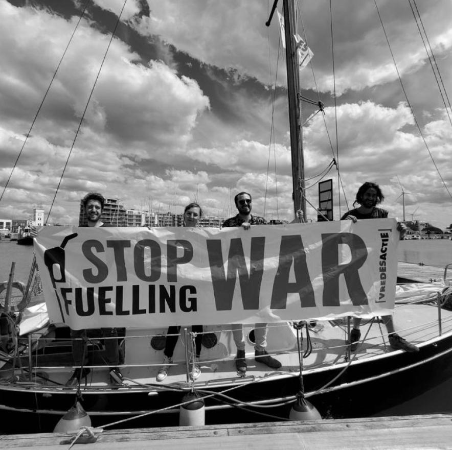 Activisten op een boot met een "stop fuelling war" banner